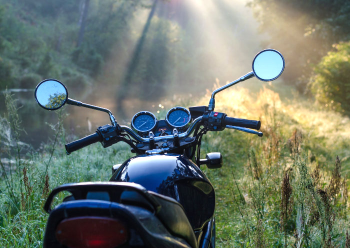 Motorrad im Wald bei Sonnenaufgang